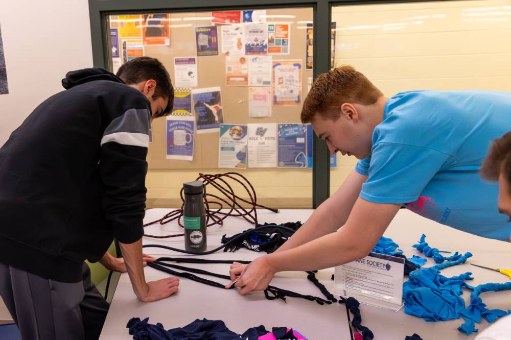 Collaborative service students making a dog toy